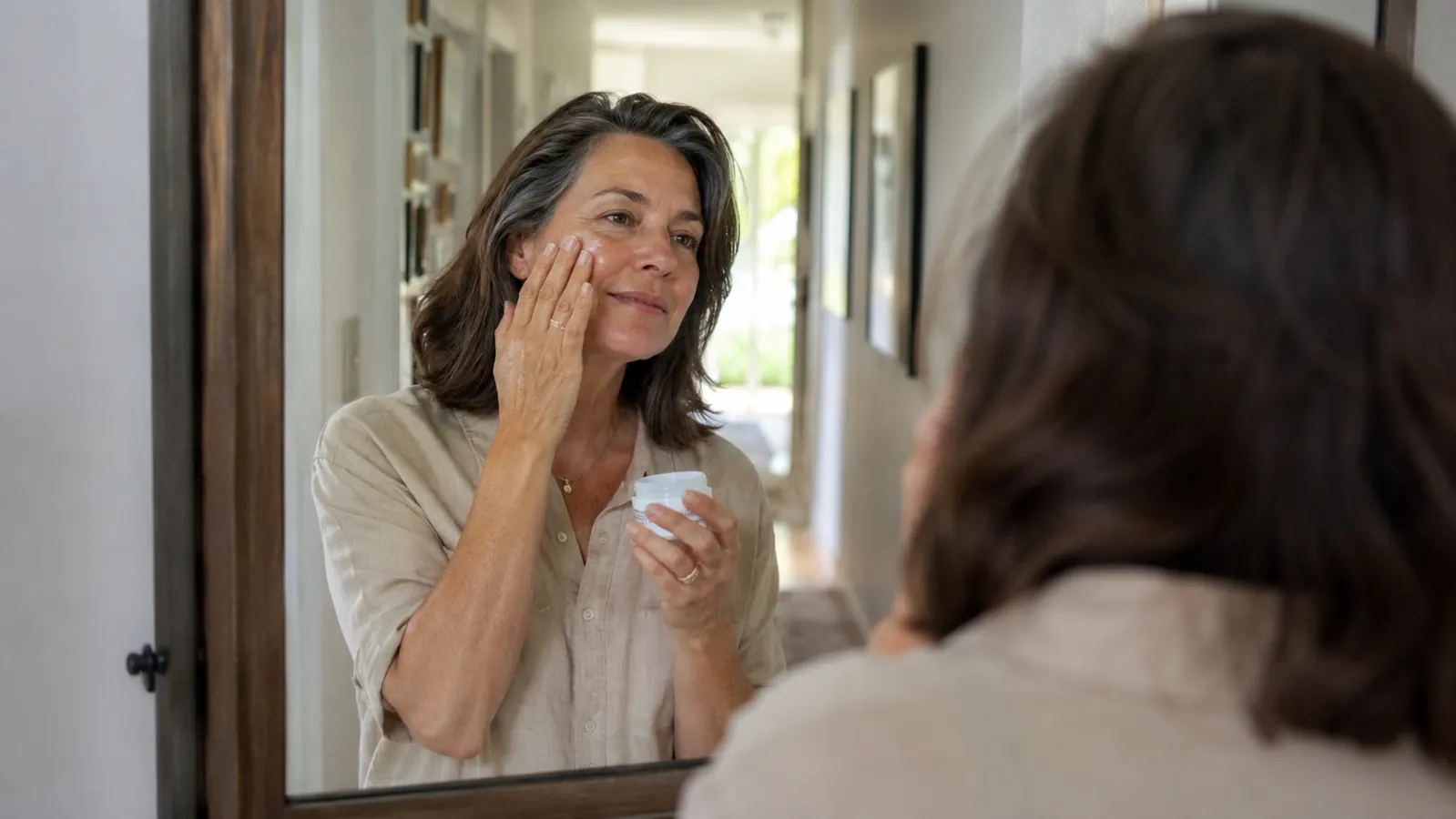Woman applying mineral sunscreen to her face before leaving the house in the morning